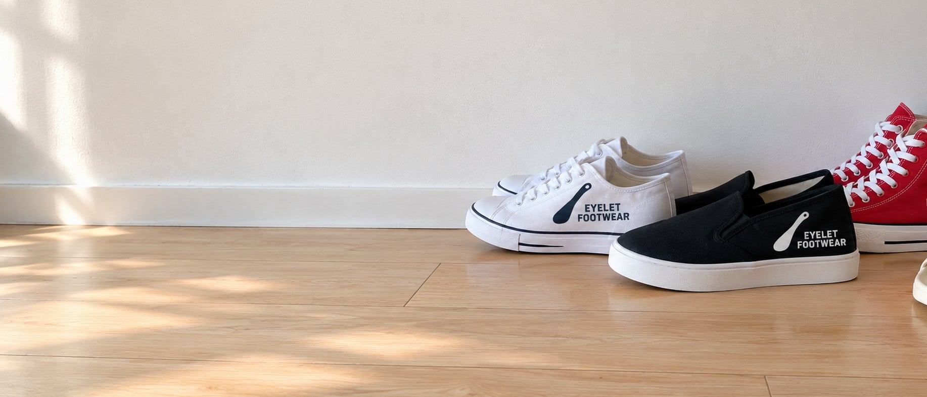 Custom printed canvas sneakers and slides lined up on a pale wooden shelf